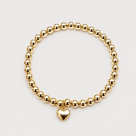 14K yellow gold ball bead stretch bracelet with dangling solid puffed heart charm, high polish finish, angled overhead view