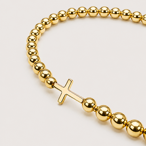 14K yellow gold ball bead stretch bracelet with polished sideways cross centerpiece, high polish finish, close-up detail view
