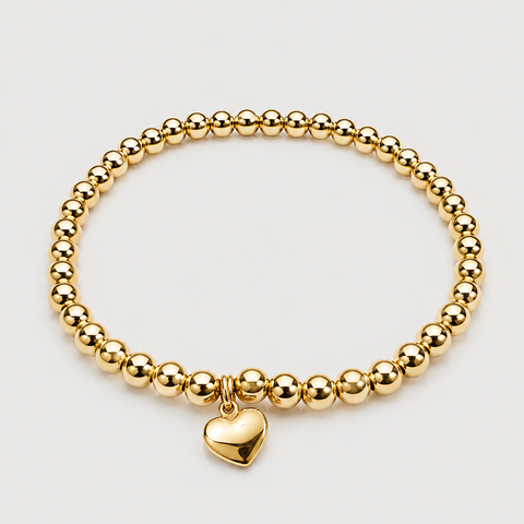 14K yellow gold ball bead stretch bracelet with solid polished puffed heart dangle charm, elastic band, flat overhead view