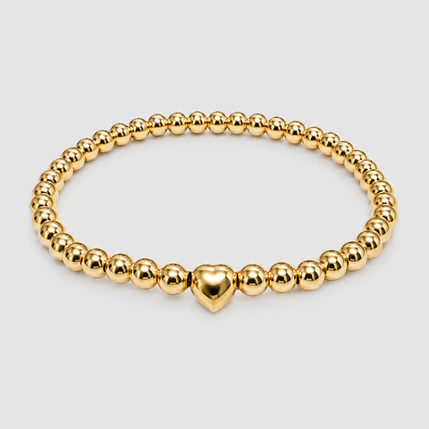 14K yellow gold ball bead stretch bracelet with solid polished puffed heart station bead, elastic band, flat overhead view