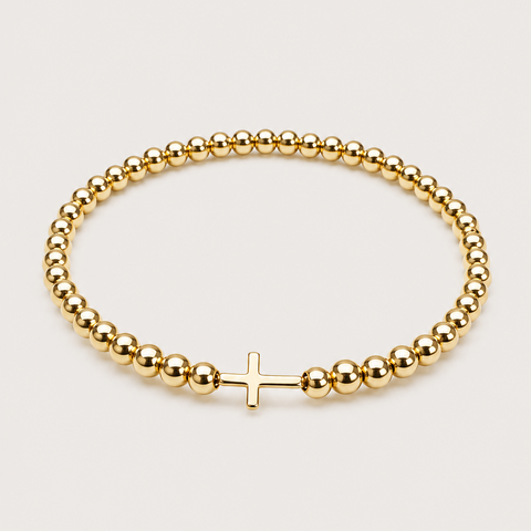 14K yellow gold ball bead stretch bracelet with solid polished sideways cross, elastic band, flat overhead view