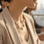 close up of model's neck 14Kt Yellow Gold Clover Necklace with Mother of Pearl and Diamond Accents – adjustable chain fine jewelry