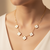 Neck of model wearing 14Kt Yellow Gold Mother of Pearl Clover Necklace with Diamond Accents – Adjustable Chain