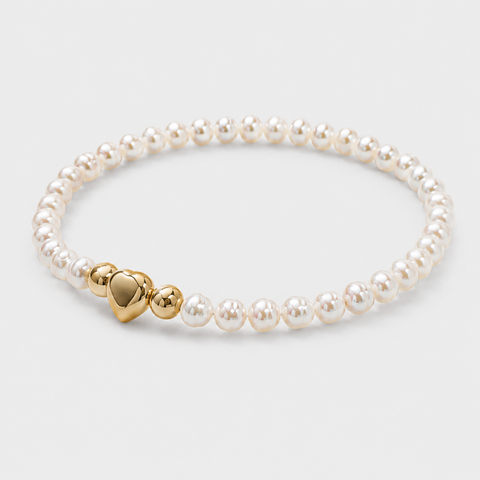 A pearl stretch bracelet with a polished gold heart-shaped clasp, displayed on a light gray background.