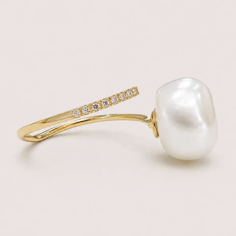 14K yellow gold pavé diamond open cuff ring with baroque white pearl side profile view showing bypass band design light background