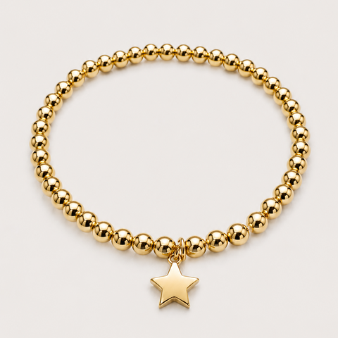 14K yellow gold ball bead stretch bracelet with dangling solid star charm, elastic band, flat overhead view