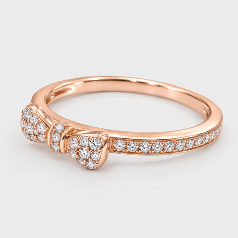 Angled view of an 18K rose gold pavé diamond bow ring showing its diamond-set band.