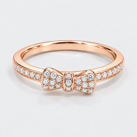 Front view of an 18K rose gold bow ring with pavé diamonds across the bow and band.