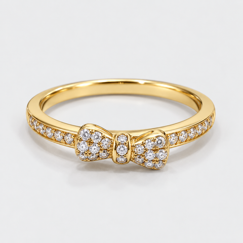 Front view of an 18K yellow gold bow ring with pavé diamonds across the bow and band.
