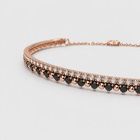18K rose gold double-row bangle bracelet close-up, black diamond bottom row and white diamond top row with gold bead separators, adjustable chain clasp visible, angled view