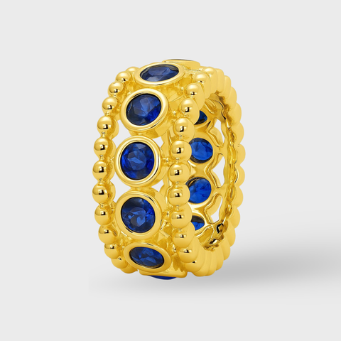 Bezel sapphire rondelle in 14K gold featuring 11 round blue sapphires framed by polished gold beading
