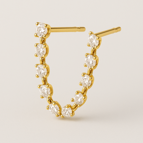 14K yellow gold double-piercing earring with prong-set round diamonds forming a curved connector between two studs.