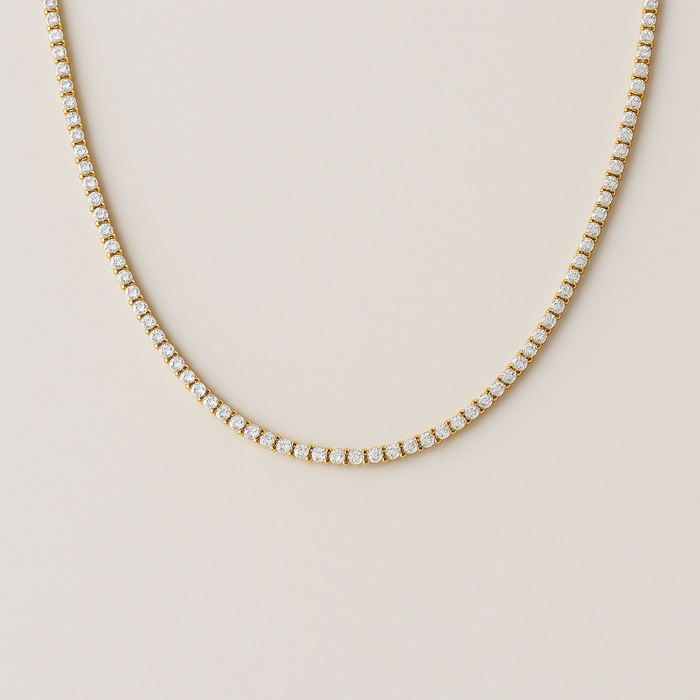 Gold necklace with diamonds on a beige background