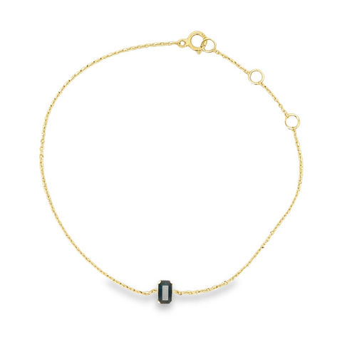 Delicate 14K gold bracelet with a single emerald-cut blue sapphire centerpiece.