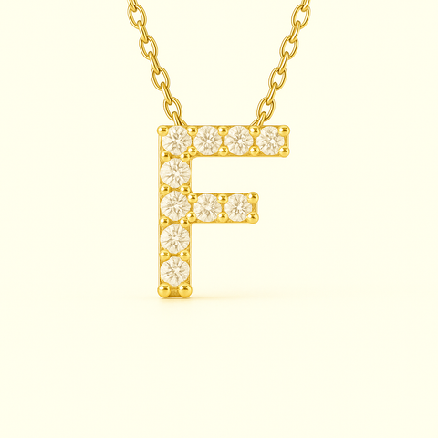 Close-up of 14K gold pavé diamond initial F pendant necklace with fine chain.