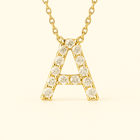 Close-up of 14K gold pavé diamond initial A pendant necklace with fine chain.