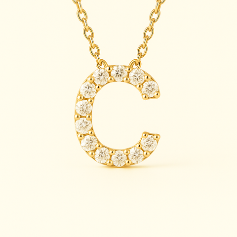 Close-up of 14K gold pavé diamond initial C pendant necklace with fine chain.
