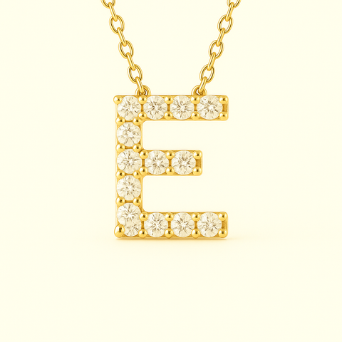Close-up of 14K gold pavé diamond initial E pendant necklace with fine chain.