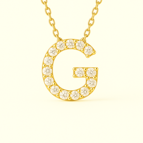 Close-up of 14K gold pavé diamond initial G pendant necklace with fine chain.