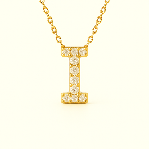 Close-up of 14K gold pavé diamond initial I pendant necklace with fine chain.