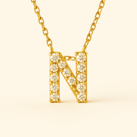 Close-up of 14K gold pavé diamond initial N pendant necklace with fine chain.