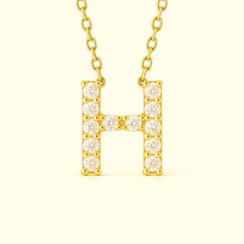 Close-up of 14K gold pavé diamond initial H pendant necklace with fine chain.