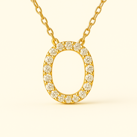 Close-up of 14K gold pavé diamond initial O pendant necklace with fine chain.