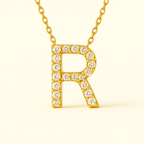 Close-up of 14K gold pavé diamond initial R pendant necklace with fine chain.