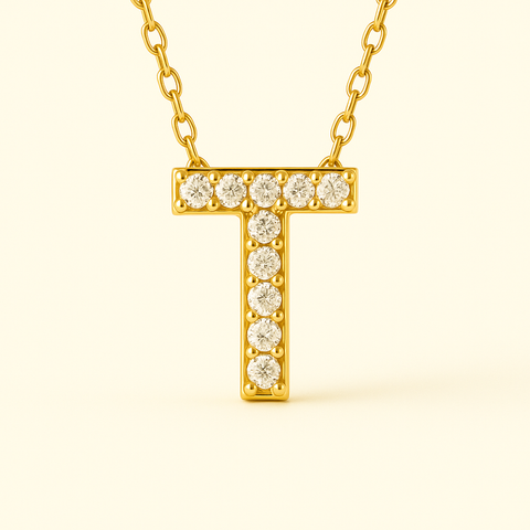 Close-up of 14K gold pavé diamond initial pendant necklace with fine chain.