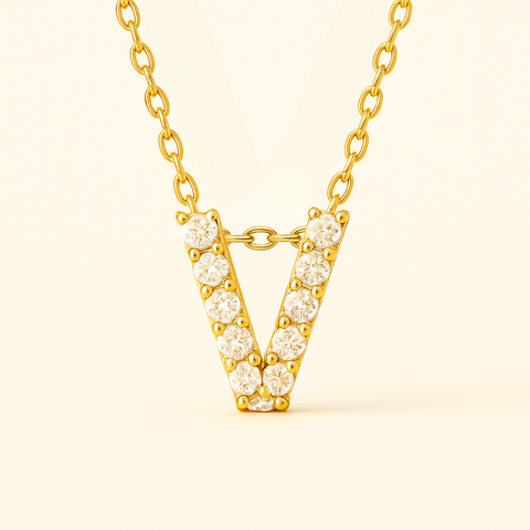 Close-up of 14K gold pavé diamond initial V pendant necklace with fine chain.