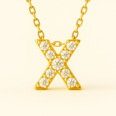 Close-up of 14K gold pavé diamond initial X pendant necklace with fine chain.