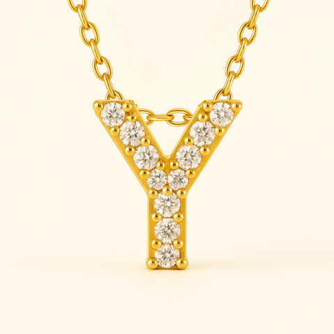 Close-up of 14K gold pavé diamond initial pendant necklace with fine chain.