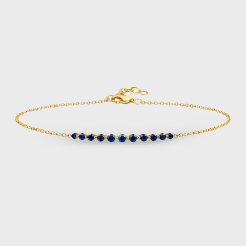 14K yellow gold bar bracelet featuring 11 round blue sapphires on an adjustable fine gold chain.