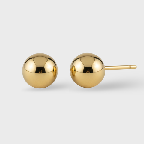Pair of gold sphere earrings on a light gray background