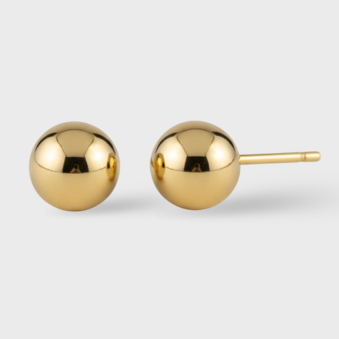 Pair of gold sphere earrings on a light gray background