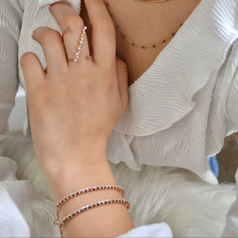 18K Rose Gold semi rigid white & black diamond bracelet with round white diamonds, side view