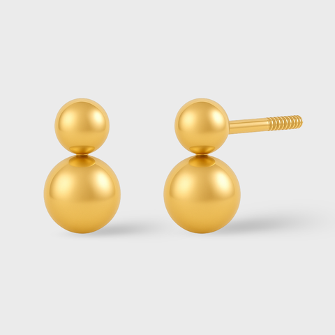Pair of gold ball earrings on a light gray background